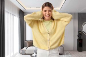 sfondo di un salotto e donna con le mani sulle orecchie per il rumore