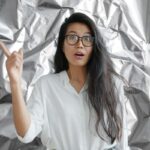 carta stagnola alle spalle e donna con idea e dito alzato