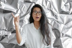 carta stagnola alle spalle e donna con idea e dito alzato