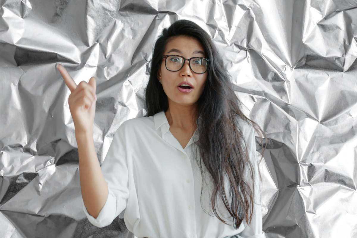 carta stagnola alle spalle e donna con idea e dito alzato