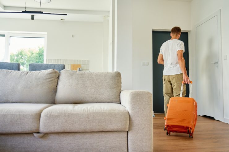 Una persona che sta uscendo di casa con una valigia
