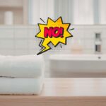 asciugamani ripiegati in un bagno e scritta no