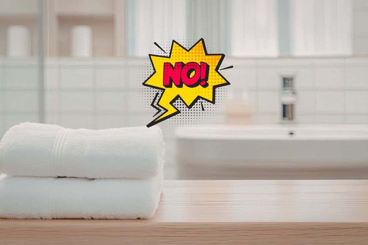 asciugamani ripiegati in un bagno e scritta no