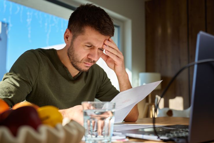 Un uomo preoccupato mentre guarda dei dati al computer
