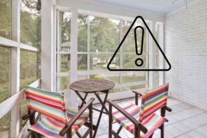 Un terrazzo chiuso con grandi finestre e con un segnale di pericolo in alto a destra