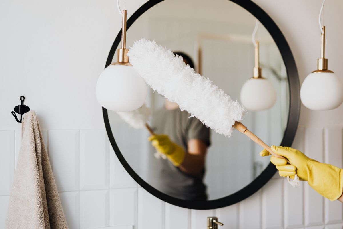 donna che rimuove polvere con lo spolverino