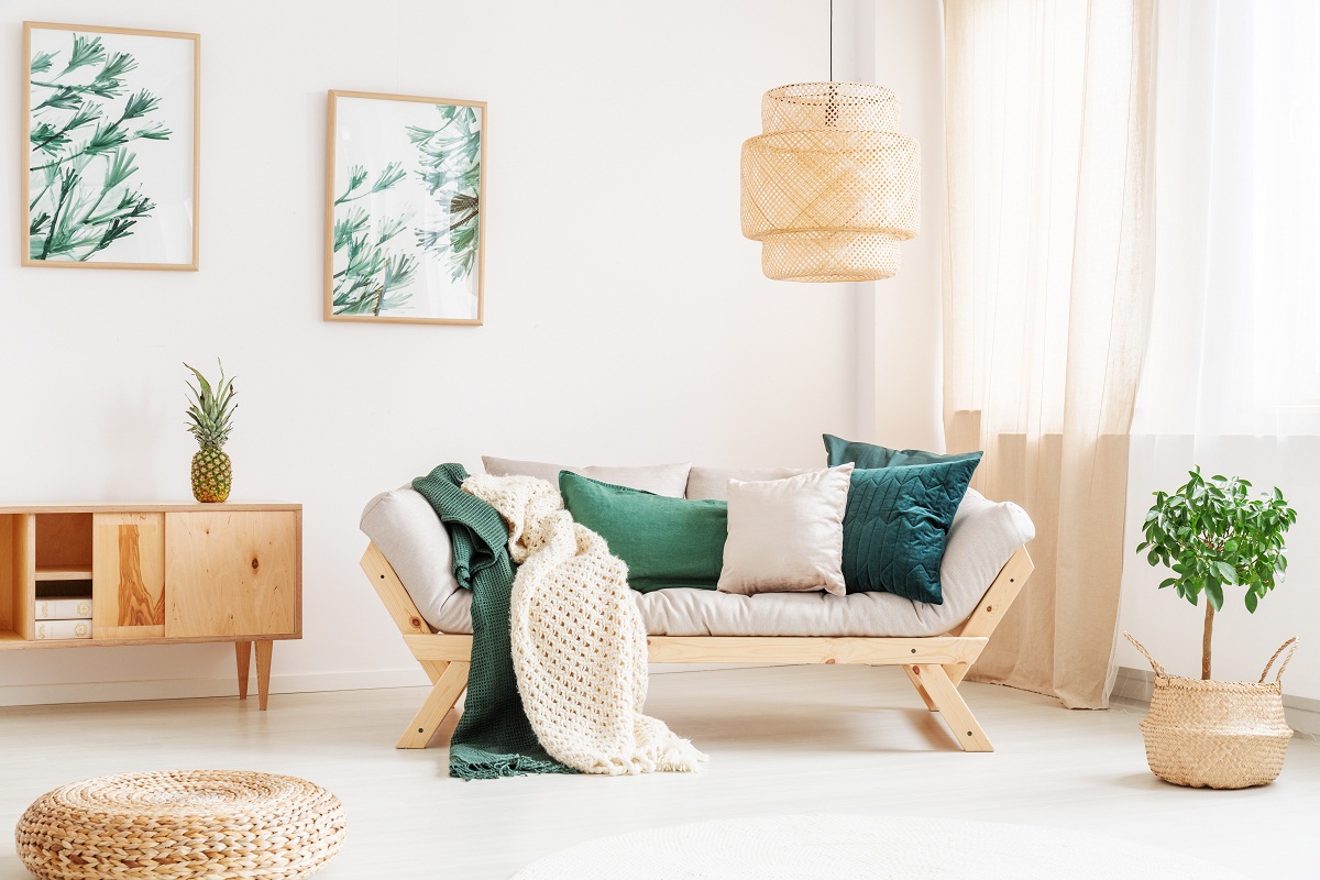Small,Tree,In,Braided,Basket,Next,To,Sofa,With,Green