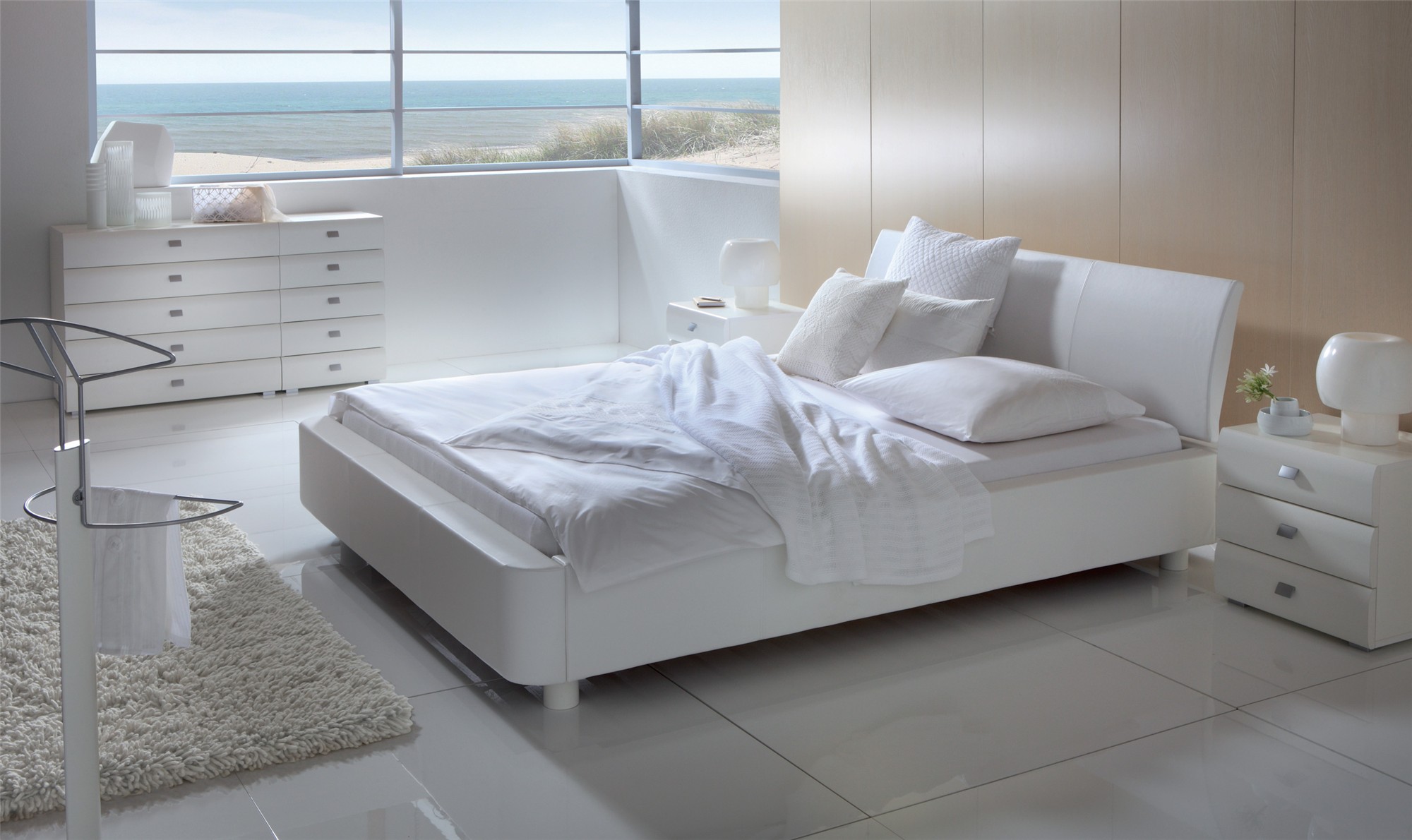 Pure white designer bed in a minimalist bedroom