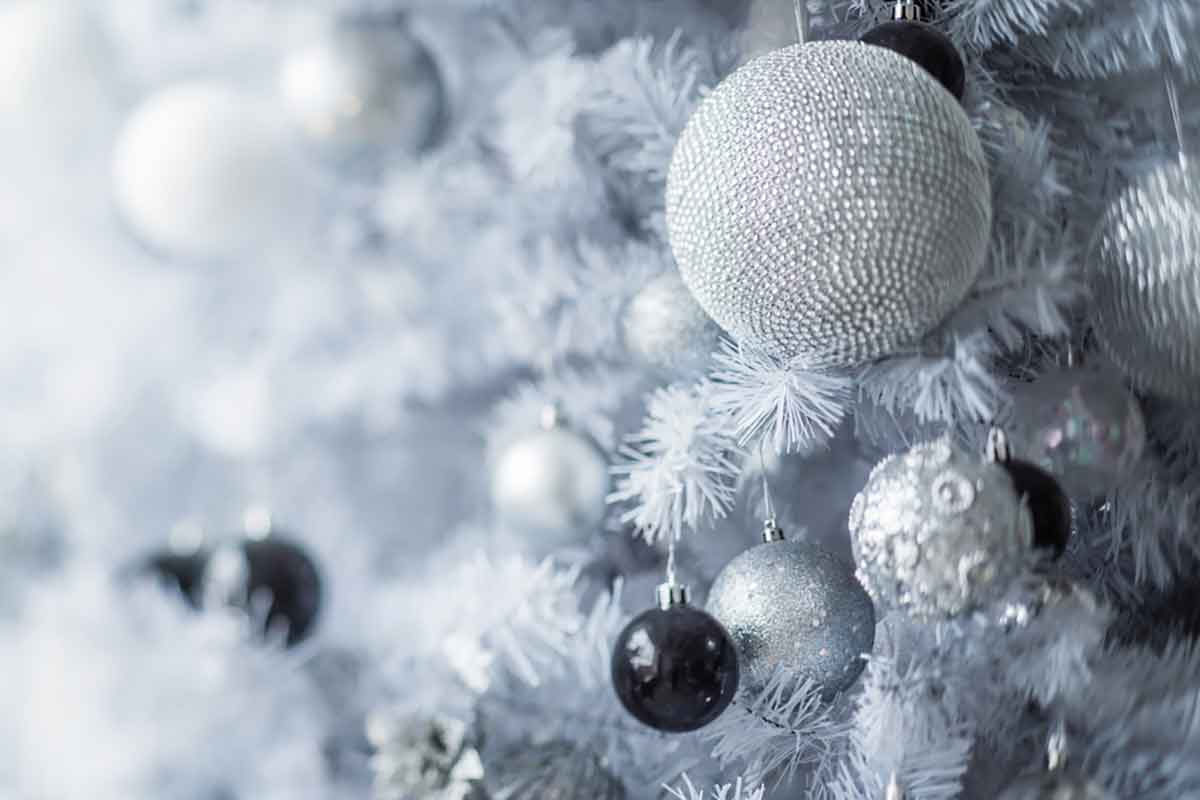 albero di natale di colore bianco con palline decorative di colore grigio e nero