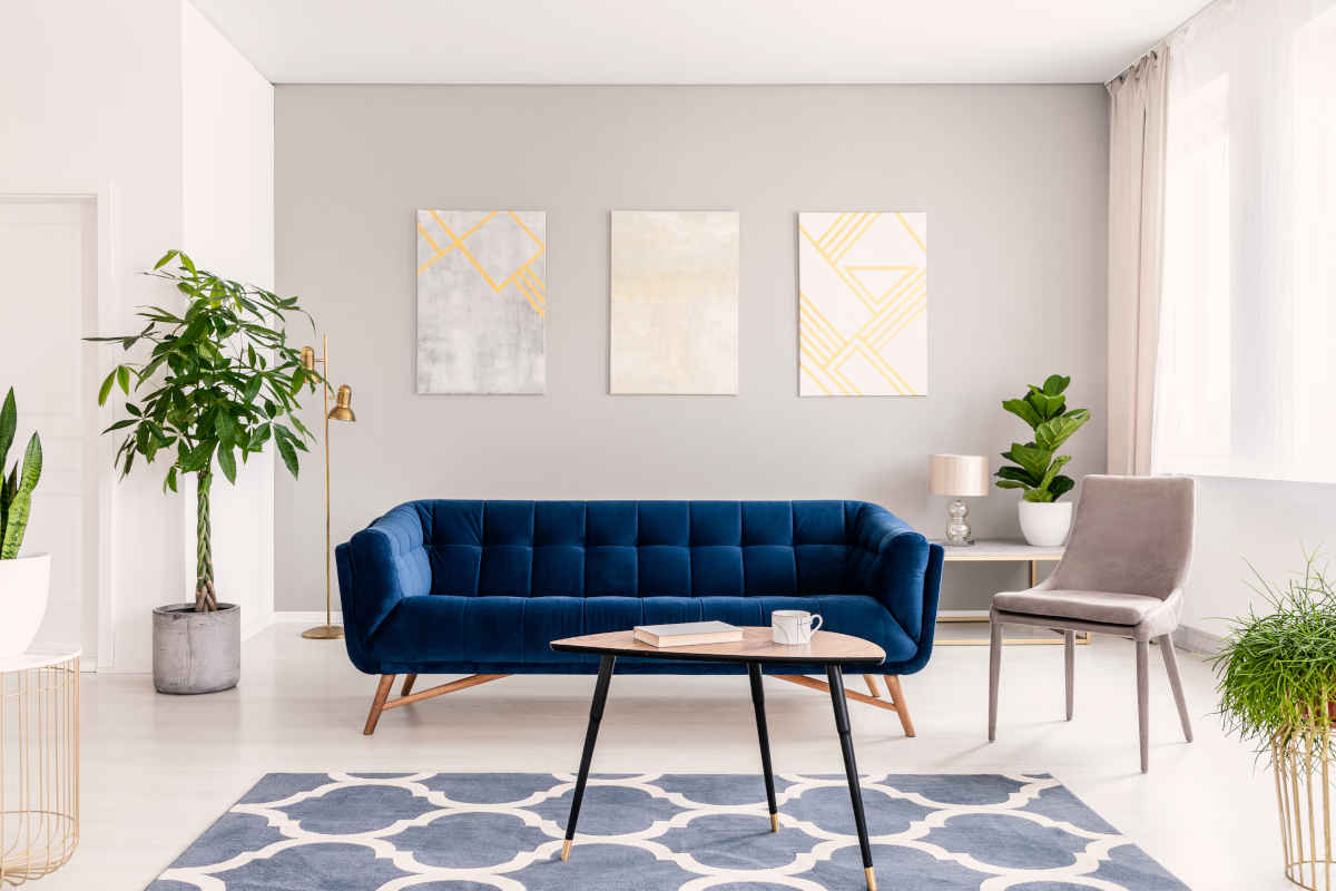 soggiorno con divano blu e tappeti con colori di tendenza 2023
